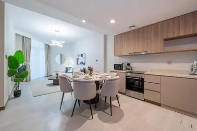 a kitchen and dining room with a table and chairs at Modern 2BR Canal-Side Elegance in Dubai