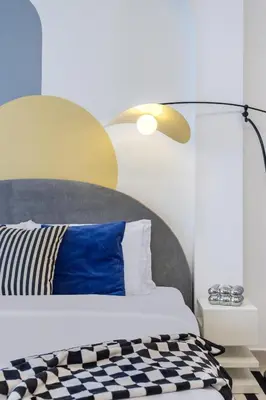 a bedroom with a bed with a blue pillow and a lamp at Modern Boutique Studio with Burj Khalifa View in Dubai