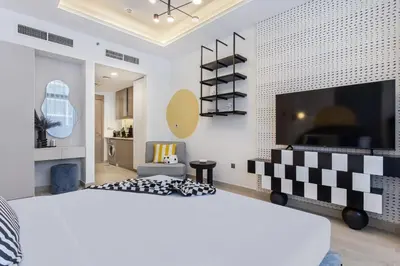 a bedroom with a large bed and a flat screen tv at Modern Boutique Studio with Burj Khalifa View in Dubai