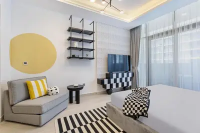 a bedroom with a bed and a couch and a tv at Modern Boutique Studio with Burj Khalifa View in Dubai