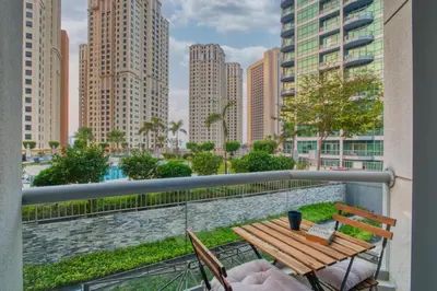 a balcony with a wooden table and chairs on a city skyline at Stunning Hideaway in Dubai Marina in Dubai