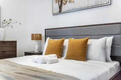 a bedroom with a large white bed with yellow pillows at Stunning Hideaway in Dubai Marina in Dubai
