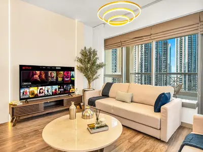 a living room with a couch and a tv at Royal Vista - Luxury 3BR Apartment at 29 Boulevard Tower - Downtown in Dubai