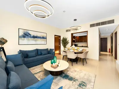 a living room with a blue couch and a table at Royal Vista - Luxury 3BR Apartment at 29 Boulevard Tower - Downtown in Dubai