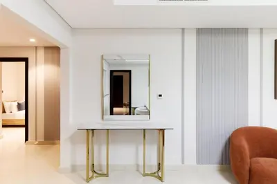 a dressing table with a mirror and a chair at Charming Sea View 2BDR, Beach and Pool Access in Dubai