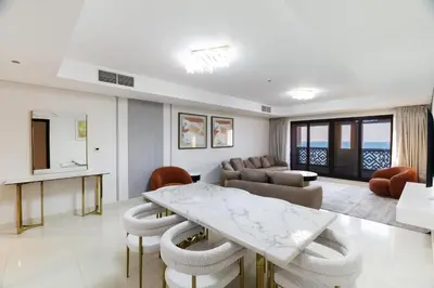 a living room with a table and chairs at Charming Sea View 2BDR, Beach and Pool Access in Dubai