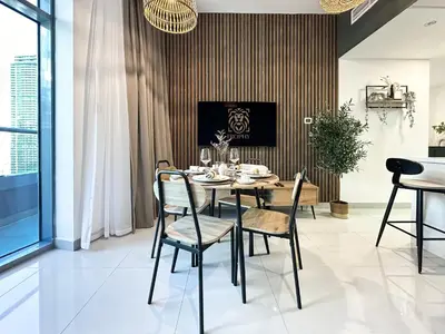 a dining room with a table and chairs at Trophy - Luxury Waterfront 2BR with Big Terrace Full Marina Canal Views in Dubai