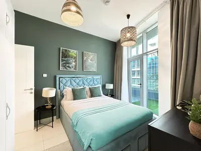 a bedroom with a bed with blue sheets and a window at Trophy - Luxury Waterfront 2BR with Big Terrace Full Marina Canal Views in Dubai