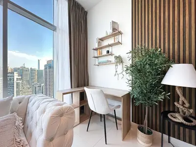 a living room with a desk and a large window at Trophy - Luxury Waterfront 2BR with Big Terrace Full Marina Canal Views in Dubai