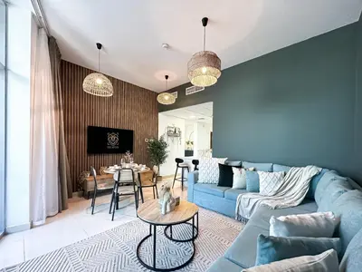 a living room with a blue couch and a table at Trophy - Luxury Waterfront 2BR with Big Terrace Full Marina Canal Views in Dubai
