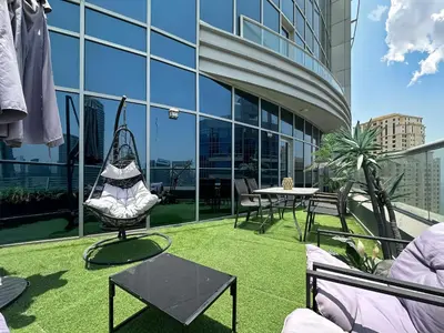 a patio with a hammock on the roof of a building at Trophy - Luxury Waterfront 2BR with Big Terrace Full Marina Canal Views in Dubai