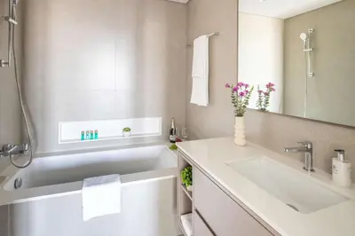 a bathroom with a white tub and a sink at Frank Porter - Grande Signature Residence in Dubai