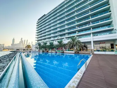a swimming pool in front of a large building at Azure Residences a Beachfront Getaway on Palm Jumeirah in Dubai