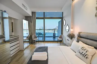 a bedroom with a large bed and a view of the water at Azure Residences a Beachfront Getaway on Palm Jumeirah in Dubai
