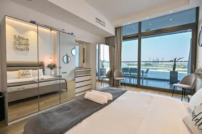 a bedroom with a large bed and a balcony at Azure Residences a Beachfront Getaway on Palm Jumeirah in Dubai