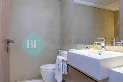 a bathroom with a white sink and a toilet at Bloomfields Stylish 1br In Azizi Riviera in Dubai