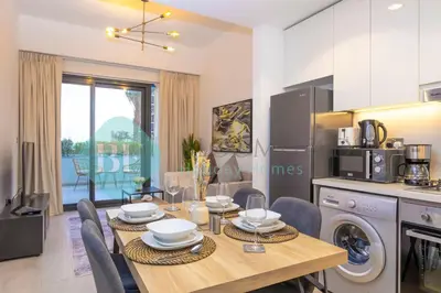 a kitchen and dining room with a table and chairs at Bloomfields Stylish 1br In Azizi Riviera in Dubai