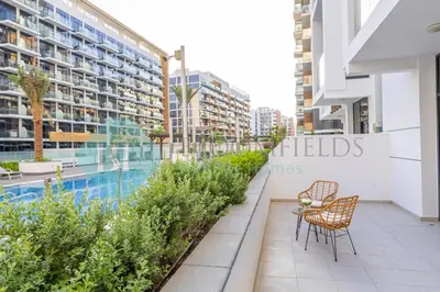a balcony with chairs and a swimming pool in a building at Bloomfields Stylish 1br In Azizi Riviera in Dubai