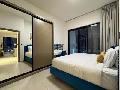a bedroom with a bed and a large glass window at Sunset View Overlooking Burj Khalifa and Canal View in Dubai