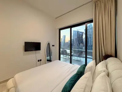 a bedroom with a white bed and a large window at Sunset View Overlooking Burj Khalifa and Canal View in Dubai