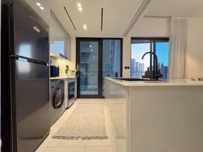 a kitchen with a stainless steel refrigerator and a dishwasher at Sunset View Overlooking Burj Khalifa and Canal View in Dubai