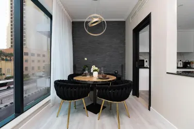 a dining room with a round table and black chairs at White Sage Spacious 1BR at Marina Promenade in Dubai