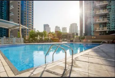 a large blue swimming pool in a city at White Sage Spacious 1BR at Marina Promenade in Dubai