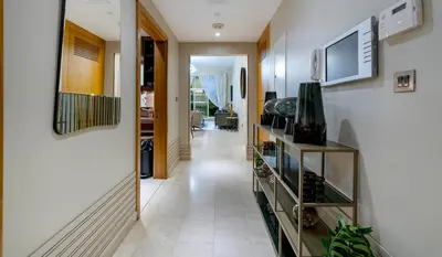 a hallway leading to a living room with a television at Usmans Brand New Duplex Apartment 5 Bedrooms Dubai Marina Trident Bayside 4 Rooms with 4 En-suite Washrooms in Dubai