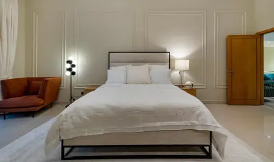 a bedroom with a large white bed and a chair at Usmans Brand New Duplex Apartment 5 Bedrooms Dubai Marina Trident Bayside 4 Rooms with 4 En-suite Washrooms in Dubai
