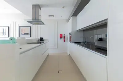 a white kitchen with white counters and appliances at 2BDR Apartment in Bluewaters Luxury Area in Dubai