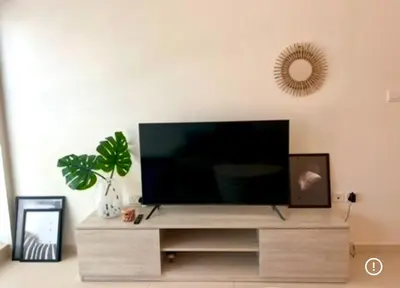a flat screen tv sitting on top of a wooden entertainment center at 1 Bedroom by the beach with free Rooftop pool access in Dubai