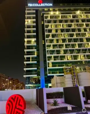 a large building in front of a hotel at night at 1 Bedroom by the beach with free Rooftop pool access in Dubai