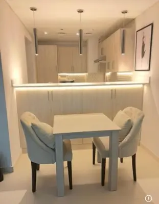 a kitchen with a table and two chairs and a counter at 1 Bedroom by the beach with free Rooftop pool access in Dubai
