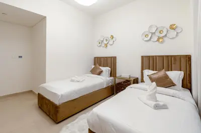 two beds in a room with white walls at 3 Bedrooms Apartment in Downtown Views - Dubai Burj Khalifa View in Dubai
