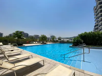 a swimming pool with lounge chairs in a hotel at Vacay Lettings -2 bed at Park ridge Dubai Hills in Dubai