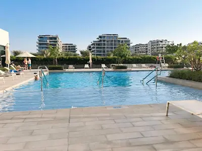 a swimming pool in a city with buildings at Vacay Lettings -2 bed at Park ridge Dubai Hills in Dubai