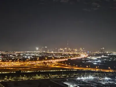 a view of a city at night with lights at Vacay Lettings -2 bed at Park ridge Dubai Hills in Dubai