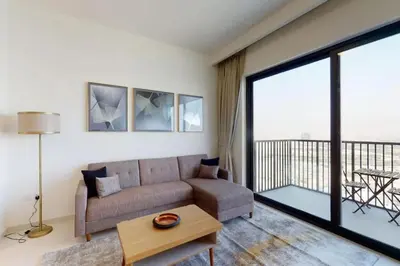 a living room with a couch and a large window at Vacay Lettings -2 bed at Park ridge Dubai Hills in Dubai