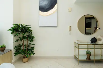 a living room with a mirror and a plant at Classy Upgraded - High Floor - Prime Location in Dubai