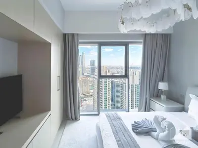 a bedroom with a bed with a large window at Burj Royale Luxury One-Bedroom with City Views in Dubai