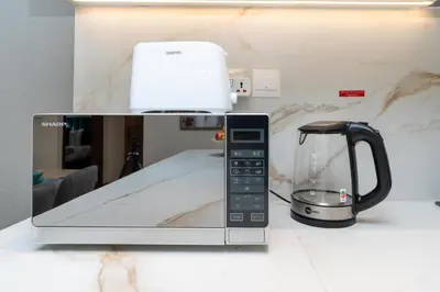 a microwave with a coffee pot on top of it at White Sage New Large 1BR at JVC in Dubai