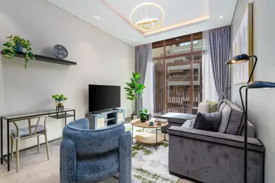 a living room with two chairs and a tv at White Sage New Large 1BR at JVC in Dubai