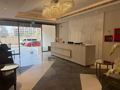 a lobby with a reception desk and a car parked in a parking lot at White Sage New Large 1BR at JVC in Dubai