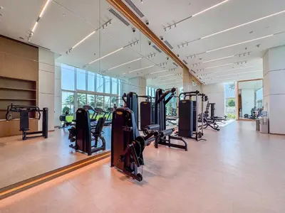 a gym with treadmills and machines in a room at Ultra-Luxury 2BR at La Vie Iconic Sea Views in Dubai