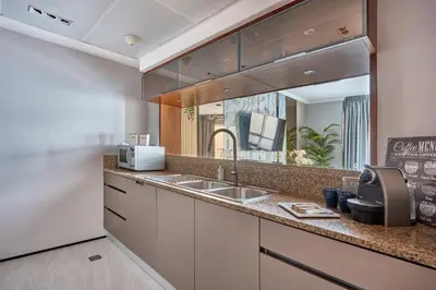 a kitchen with a sink and a large mirror at Frank Porter - Marina Quays East Tower in Dubai