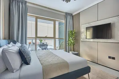 a bedroom with a bed with a television and a balcony at Frank Porter - Marina Quays East Tower in Dubai