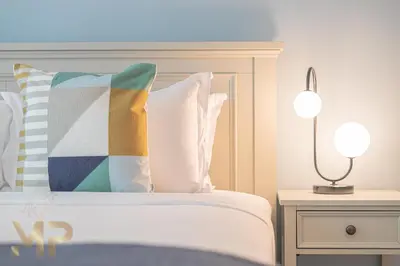 a bedroom with a bed with colorful pillows and a lamp at Marcopolo - Experience luxury living with lake views in JLT in Dubai