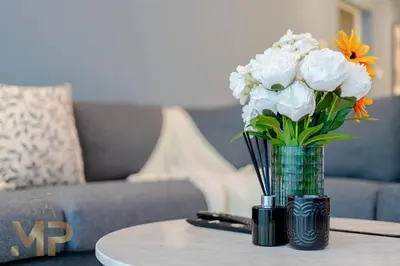 a vase of flowers on a table in a living room at Marcopolo - Experience luxury living with lake views in JLT in Dubai