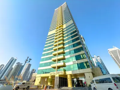 a tall skyscraper with cars parked in front of it at Marcopolo - Experience luxury living with lake views in JLT in Dubai