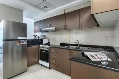 a kitchen with a stainless steel refrigerator and a sink at ShoresInn - A sublime stay in Dubai Marina in Dubai
